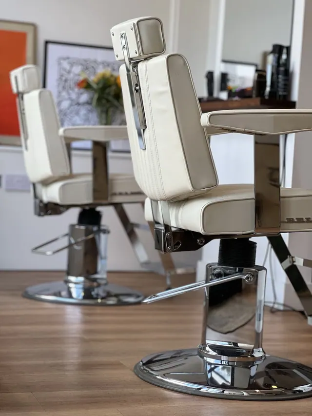 A cream barber chair at TINY's Barbershop